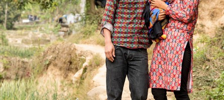 Photo of man and woman holding their baby.